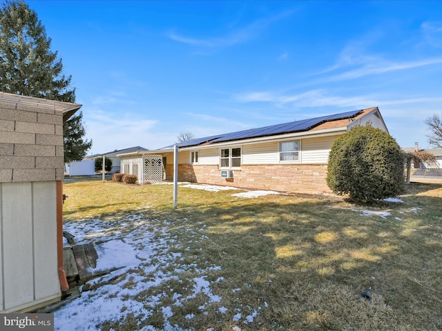 view of side of home with stone siding, roof mounted solar panels, and a yard