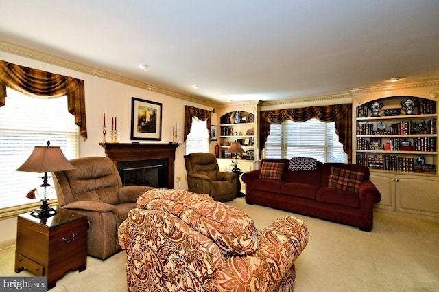 living room with ornamental molding, a glass covered fireplace, light carpet, and plenty of natural light