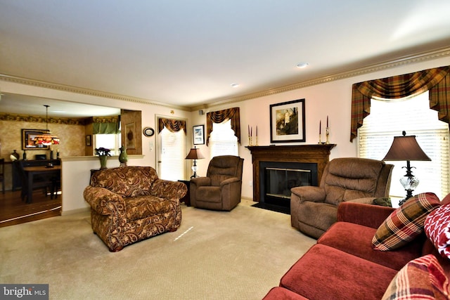 living room with light carpet, ornamental molding, a fireplace with flush hearth, and a wealth of natural light