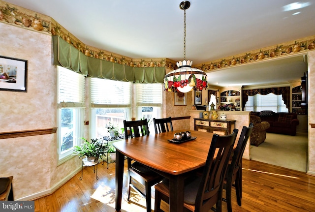 dining area featuring wood finished floors and a healthy amount of sunlight