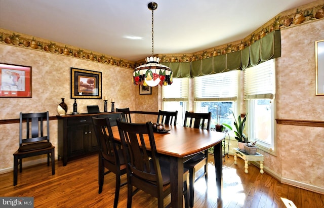 dining area with baseboards and wood finished floors