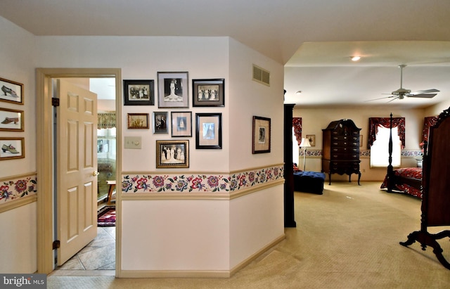 hall with visible vents and light carpet