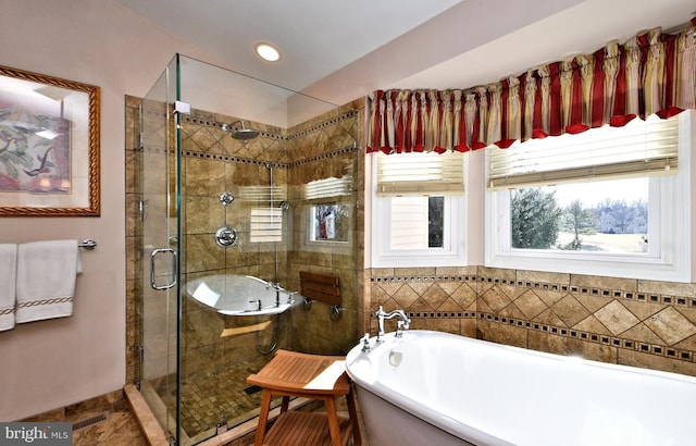 full bathroom featuring a stall shower, a soaking tub, and recessed lighting