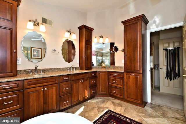 full bath featuring double vanity, a sink, and visible vents