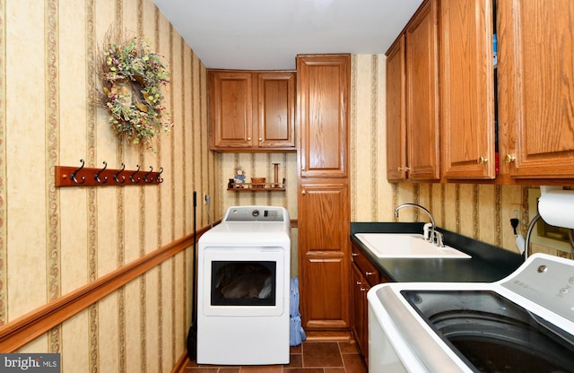 laundry area featuring washer and dryer, cabinet space, a sink, and wallpapered walls