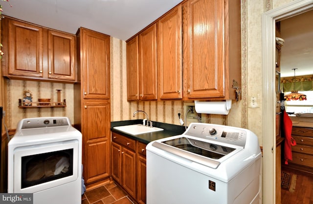 clothes washing area featuring washer and clothes dryer, a sink, and cabinet space