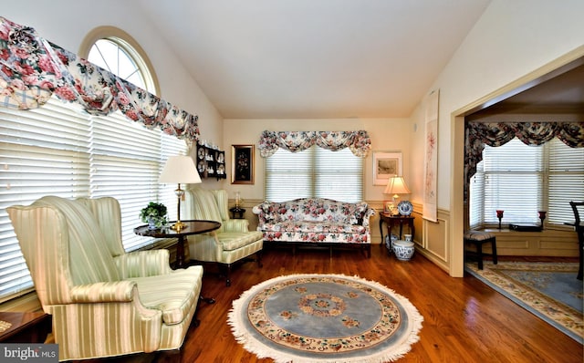 sitting room with vaulted ceiling, wainscoting, and plenty of natural light