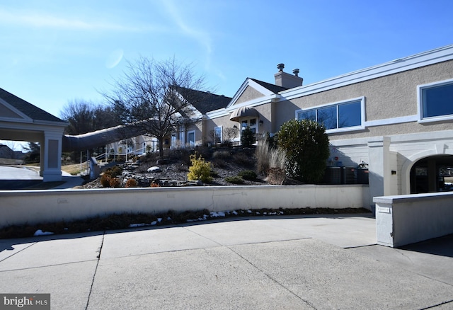 exterior space featuring a chimney and stucco siding