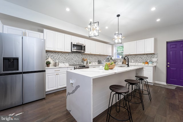 kitchen featuring a center island with sink, appliances with stainless steel finishes, and white cabinets