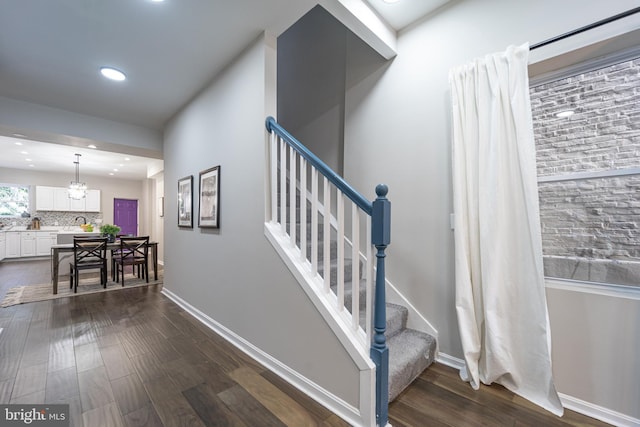 stairs featuring baseboards, wood finished floors, and recessed lighting