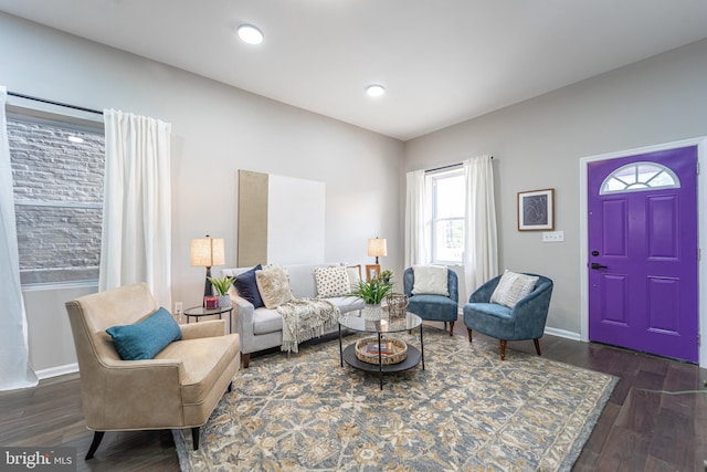 living room featuring dark wood-type flooring, recessed lighting, and baseboards