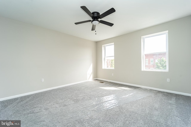 unfurnished room featuring carpet floors, a ceiling fan, and baseboards