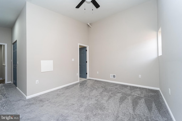 empty room with baseboards, visible vents, and ceiling fan