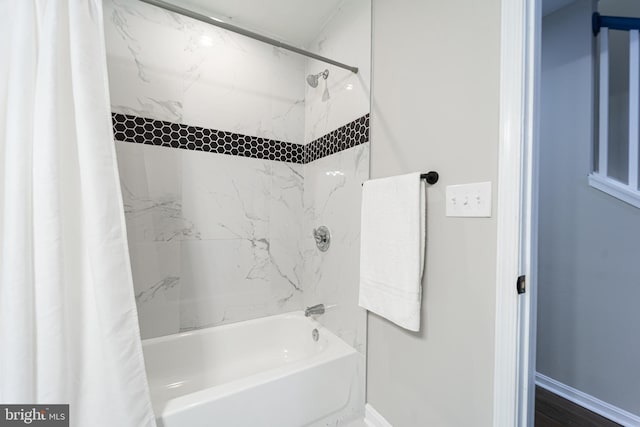 bathroom featuring baseboards and shower / bath combination with curtain