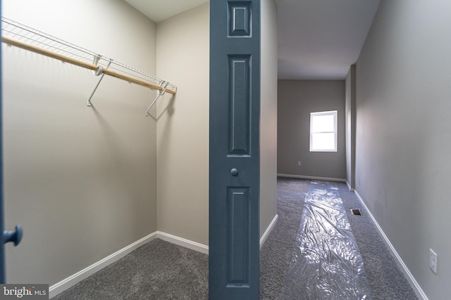 walk in closet with dark colored carpet and visible vents