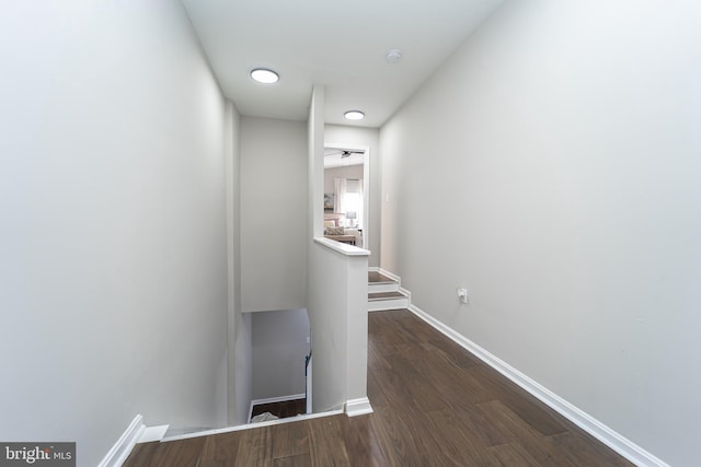 hall featuring dark wood-style floors and baseboards