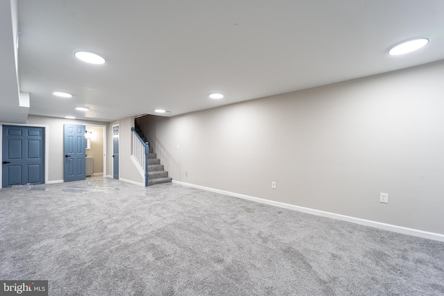 finished below grade area with carpet, stairway, baseboards, and recessed lighting