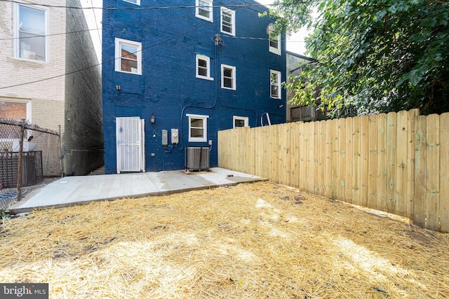 back of house featuring a patio area, brick siding, central AC unit, and fence