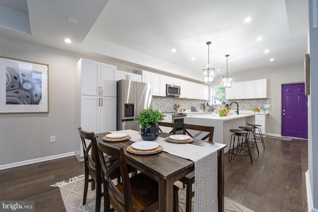 dining room with baseboards, dark wood finished floors, and recessed lighting