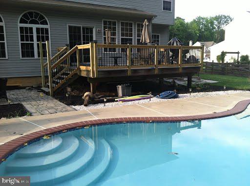 pool with a patio area and a deck