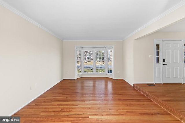 interior space with light wood-style floors, baseboards, and crown molding