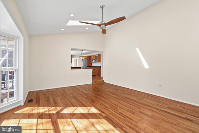 unfurnished living room with a skylight, recessed lighting, visible vents, a ceiling fan, and wood finished floors