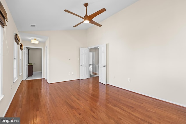 unfurnished bedroom featuring visible vents, vaulted ceiling, baseboards, and hardwood / wood-style flooring