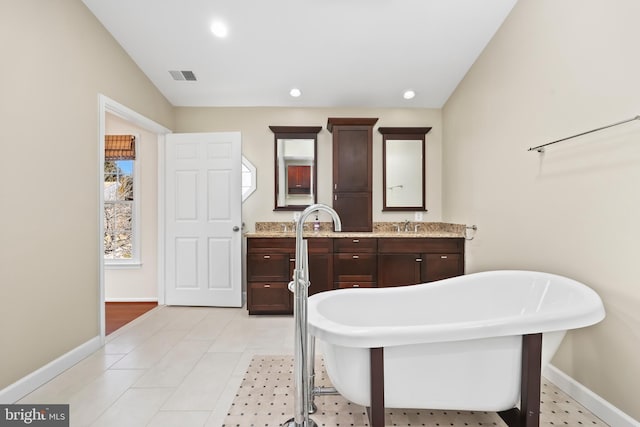 bathroom featuring a soaking tub, baseboards, visible vents, and recessed lighting