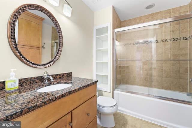 bathroom featuring combined bath / shower with glass door, vanity, toilet, and tile patterned floors