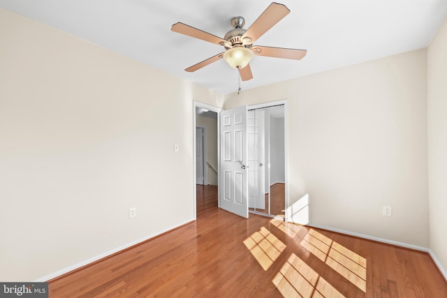 spare room with light wood finished floors, ceiling fan, and baseboards