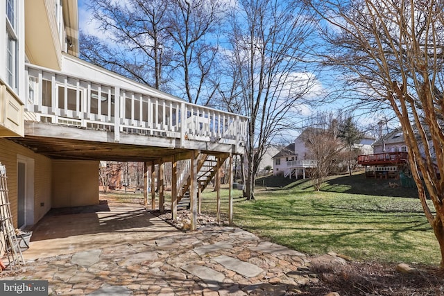 view of yard featuring a patio area, stairway, a deck, and a carport