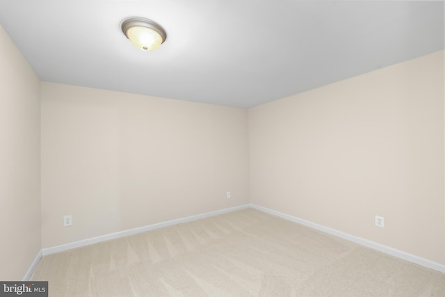 spare room with light colored carpet and baseboards