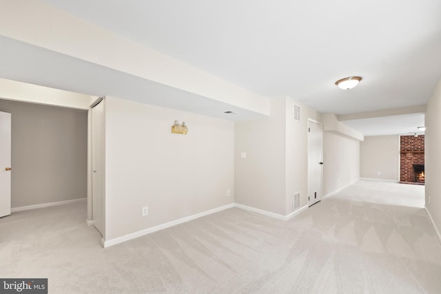 spare room with baseboards, visible vents, a fireplace, and carpet flooring