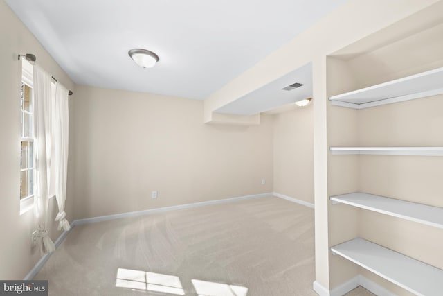 empty room featuring carpet floors, visible vents, and baseboards