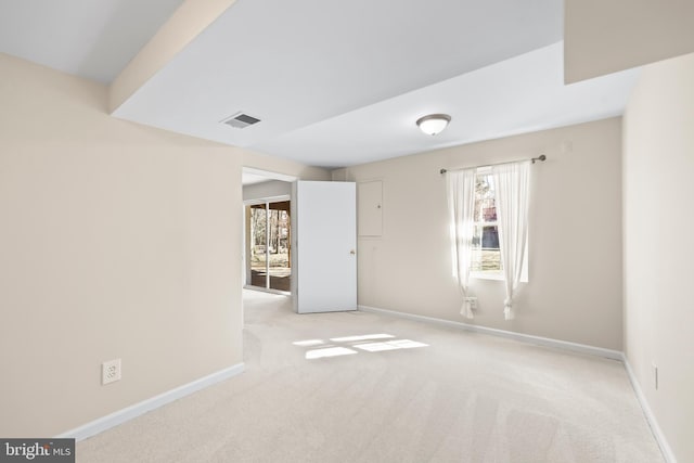 unfurnished room featuring carpet floors, visible vents, and baseboards