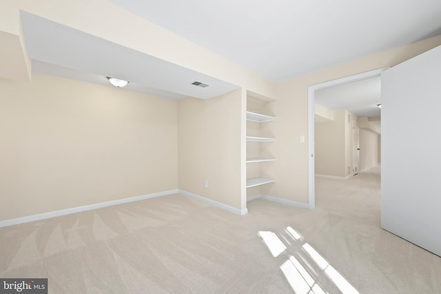 spare room featuring built in features, carpet flooring, visible vents, and baseboards