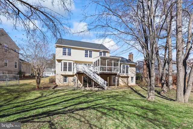 rear view of property featuring a chimney, a lawn, stairway, a sunroom, and fence