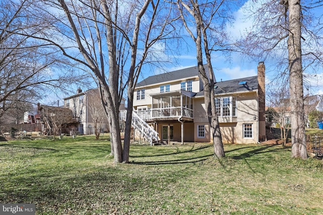 back of property featuring stairs, a lawn, a chimney, and a sunroom