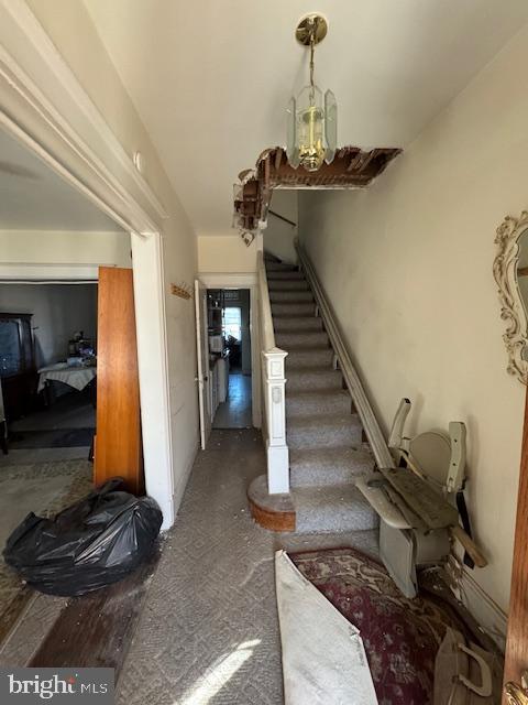 stairway with a chandelier