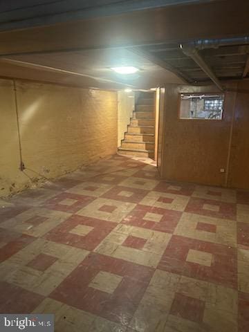 finished basement featuring light floors and stairway