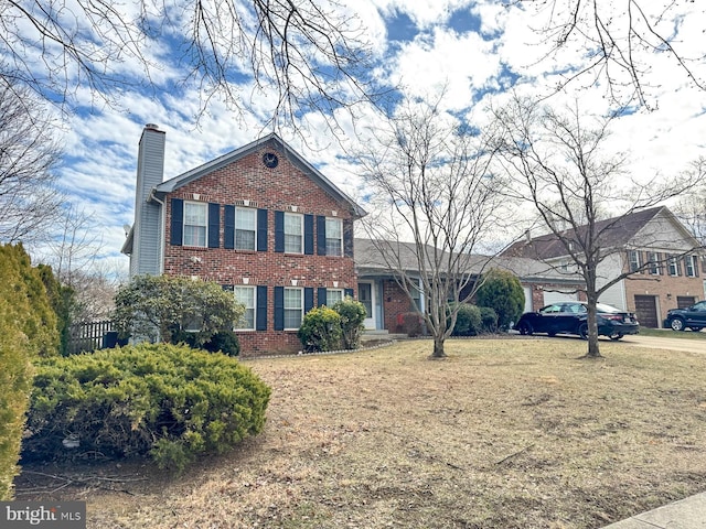 view of front of property featuring brick siding and a chimney