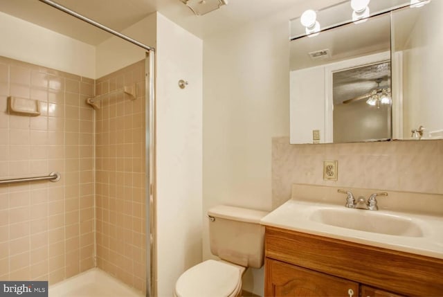 bathroom featuring ceiling fan, a stall shower, vanity, and toilet