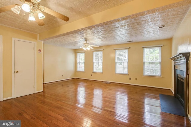 unfurnished living room featuring plenty of natural light, a fireplace, and wood-type flooring