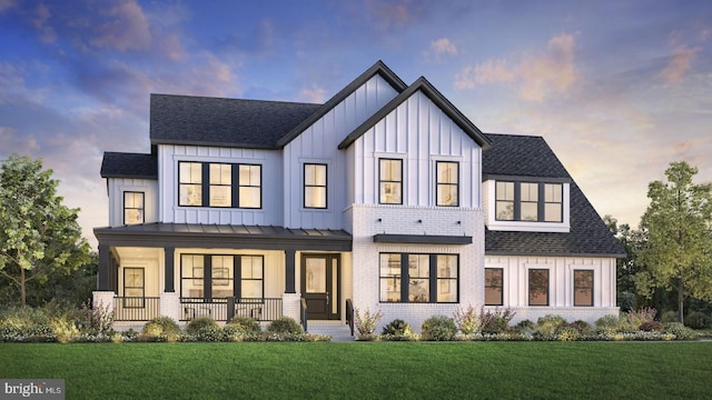 view of front facade with a porch, a front lawn, board and batten siding, and brick siding