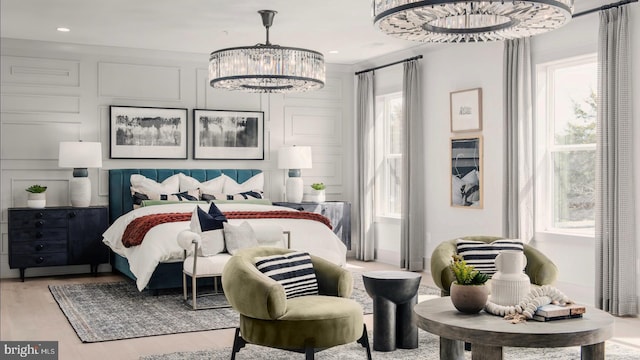 bedroom featuring a chandelier, recessed lighting, light wood-type flooring, and a decorative wall