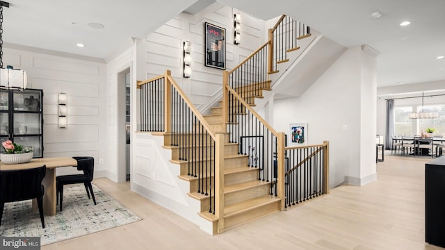 stairway with wood finished floors and recessed lighting