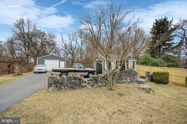 17035 Virginia Ave, Williamsport, MD 21795 - view of front of home with a detached garage, aphalt driveway, fence, an outbuilding, and a front lawn