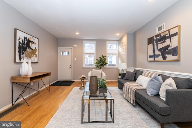 living area with light wood finished floors, baseboards, visible vents, and recessed lighting