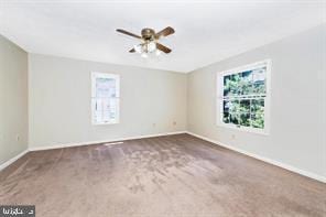 empty room featuring carpet and baseboards