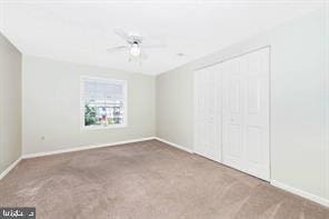 unfurnished bedroom featuring a closet, carpet flooring, ceiling fan, and baseboards